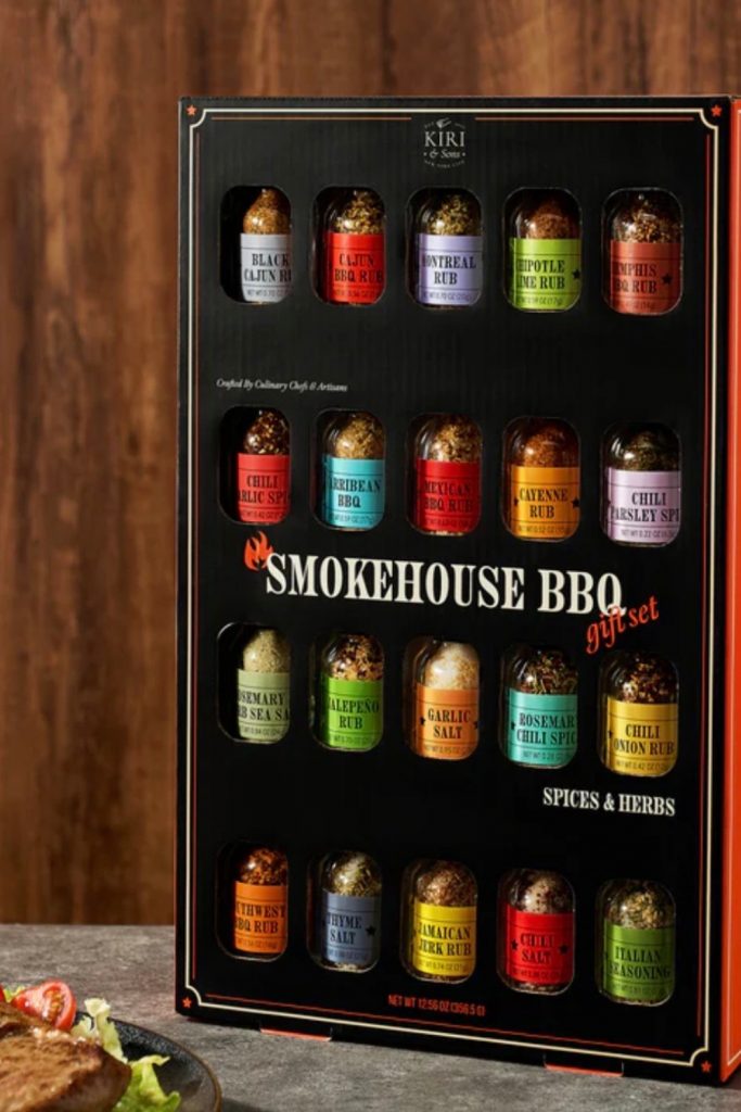 A colorful and premium gift set featuring a variety of unique grilling spices and meat rubs in small glass bottles, branded as Smokehouse by Thoughtfully Gourmet.