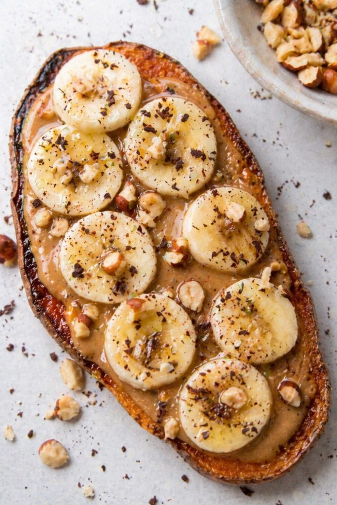 Banana sweet potato with peanut butter, sliced banana and honey on baked sweet potato halves.