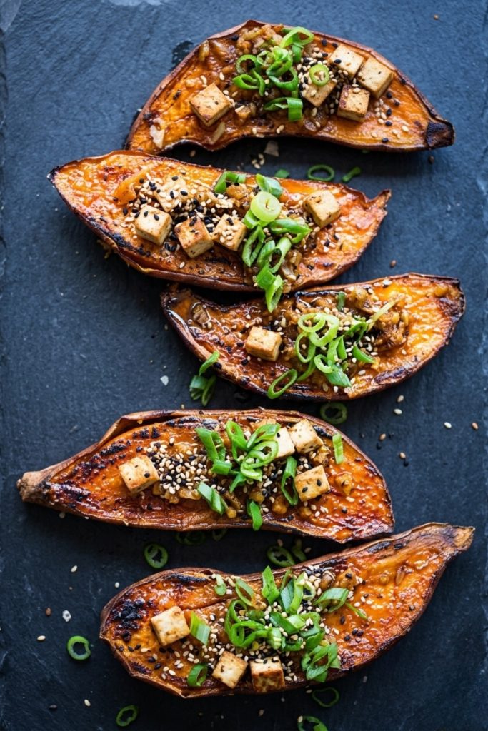 Oven-roasted miso sweet potato boats with crispy tofu cubes and sesame seeds