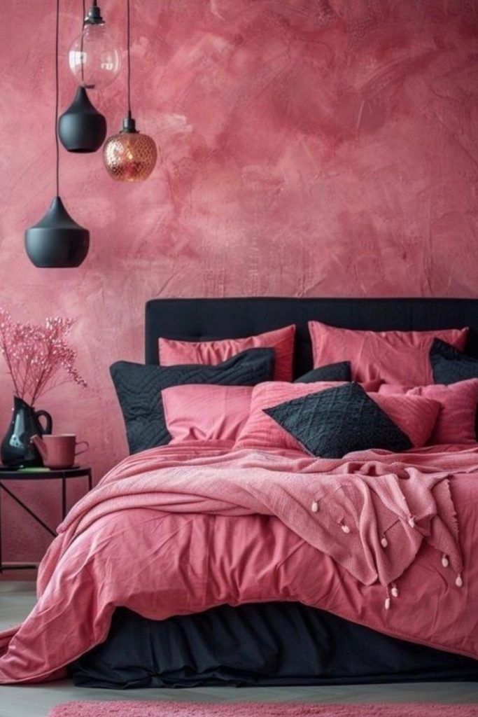 Bold pink red bedroom with black accents, soft layered bedding and modern lighting creating a vibrant and stylish atmosphere